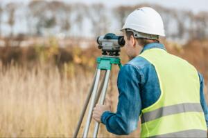 surveyor looking through digital level in field