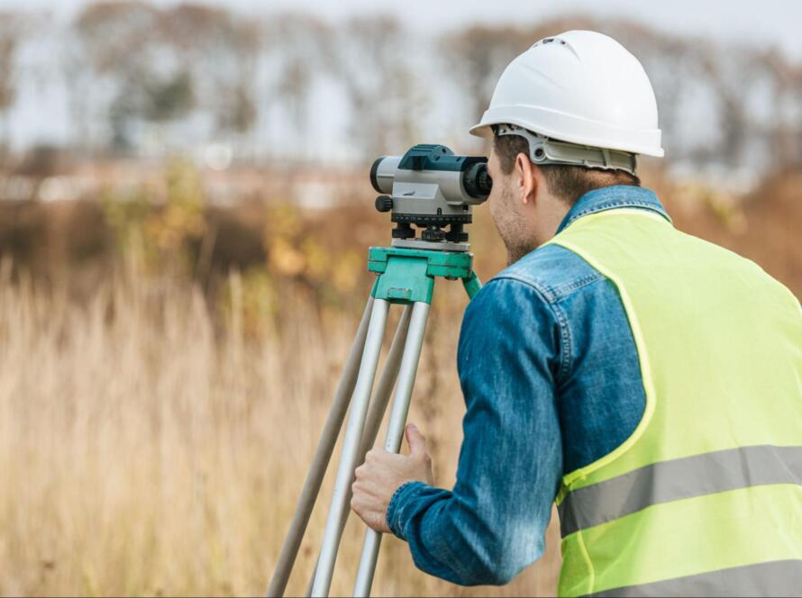 surveyor looking through digital level in field