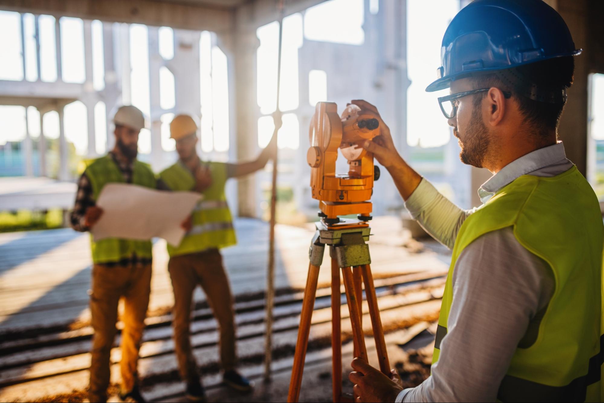 Land surveying professional adjusting theodolite