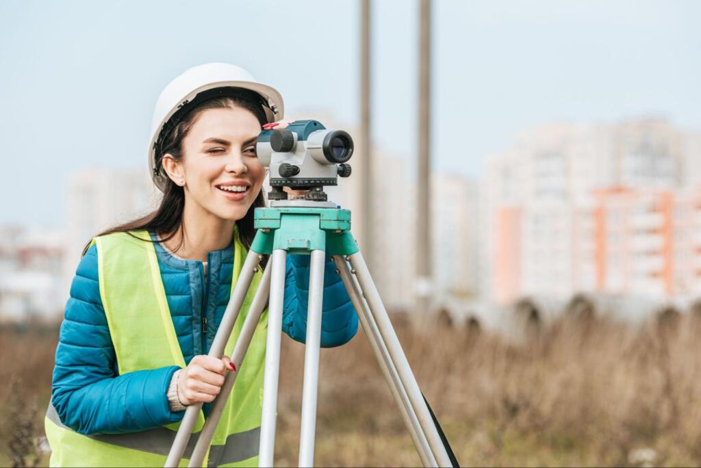 land surveyor using a digital level on a tripod to measure property boundaries after receiving the question how to request for land surveying services