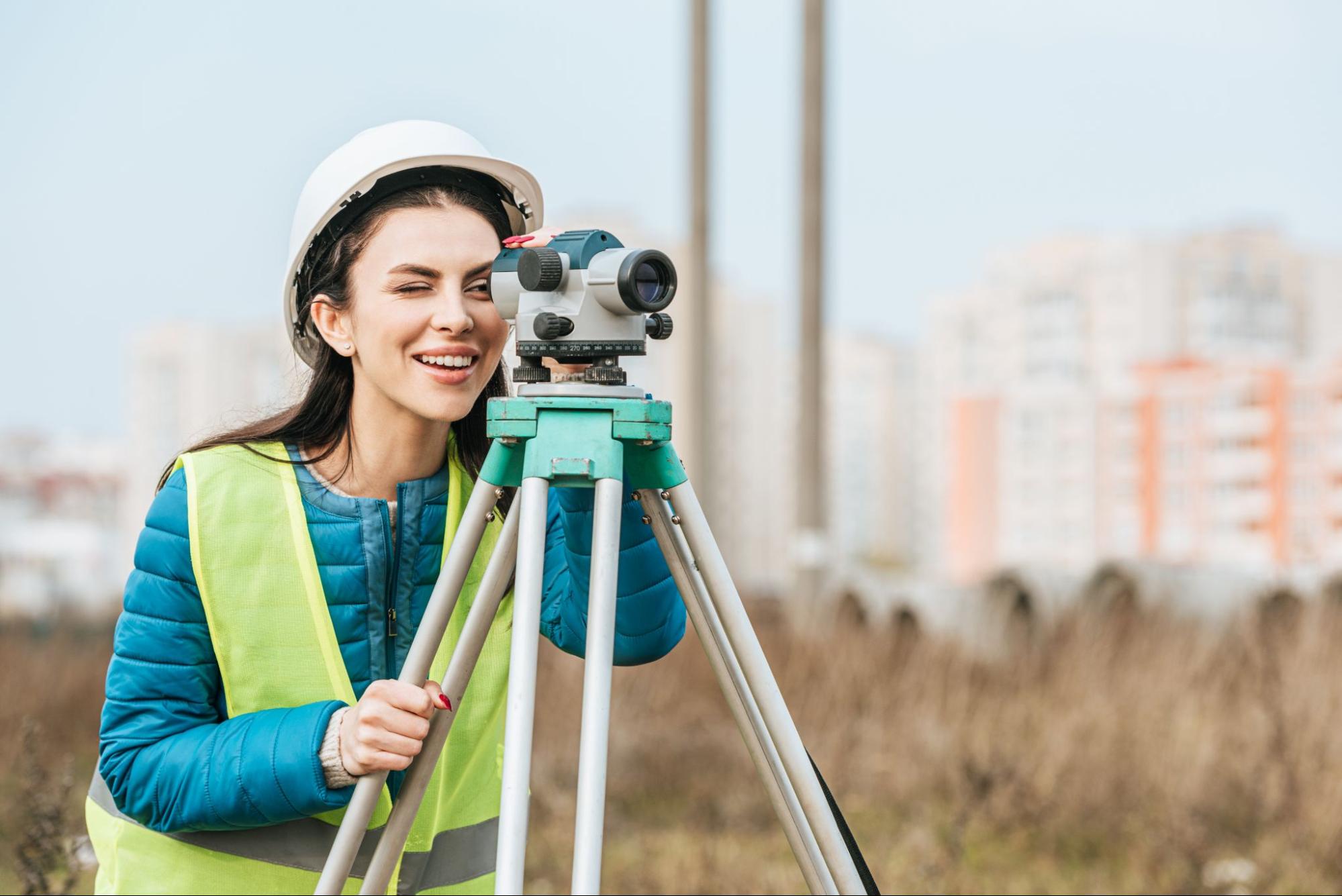 land surveyor using a digital level on a tripod to measure property boundaries after receiving the question how to request for land surveying services