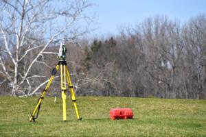 surveying equipment on tripod measuring land boundaries for how to book land surveying services guide