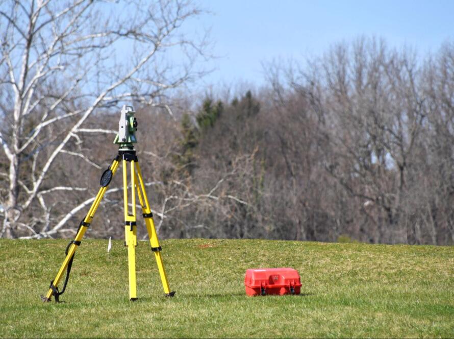 surveying equipment on tripod measuring land boundaries for how to book land surveying services guide