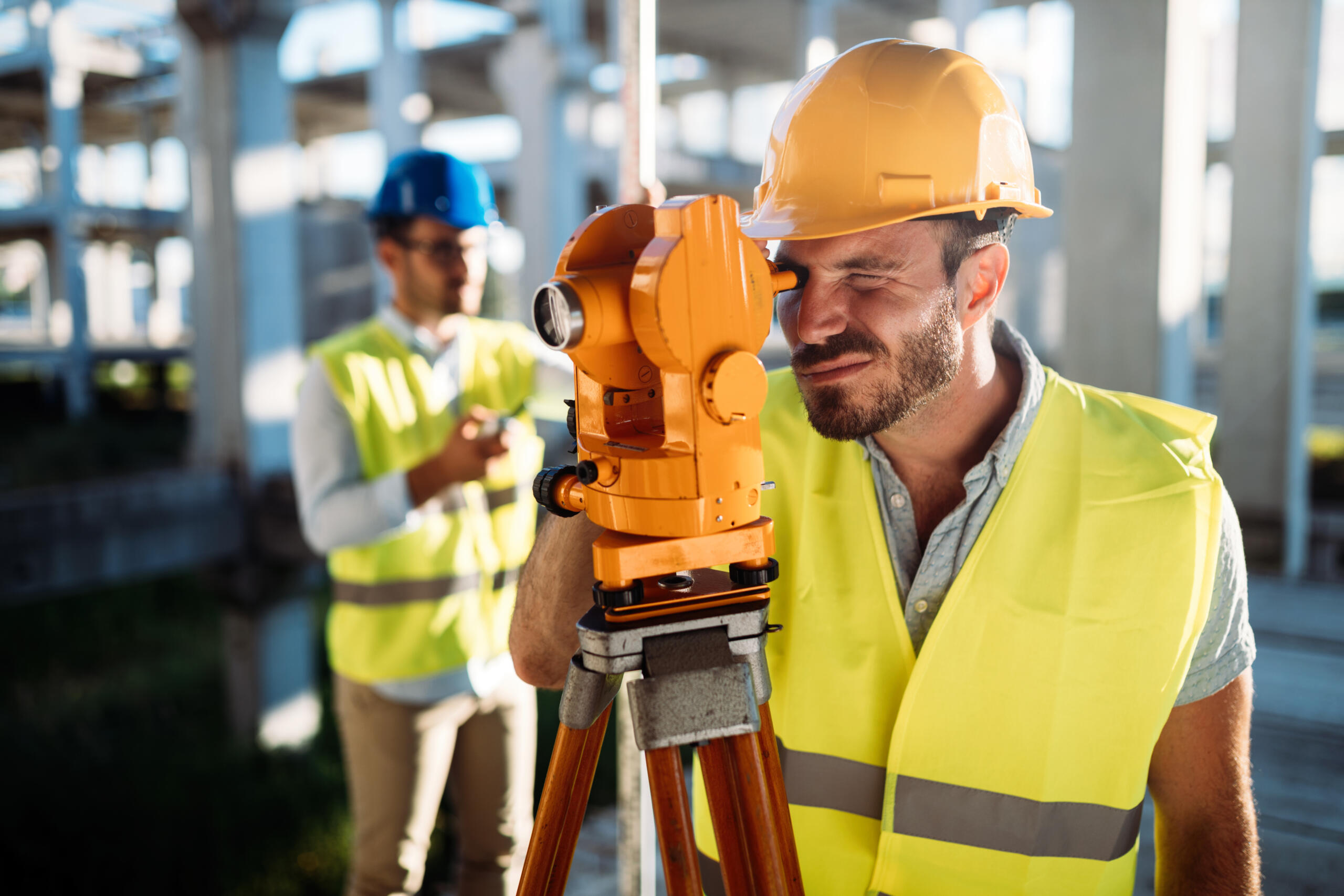 Land surveyor using total station on a commercial construction site