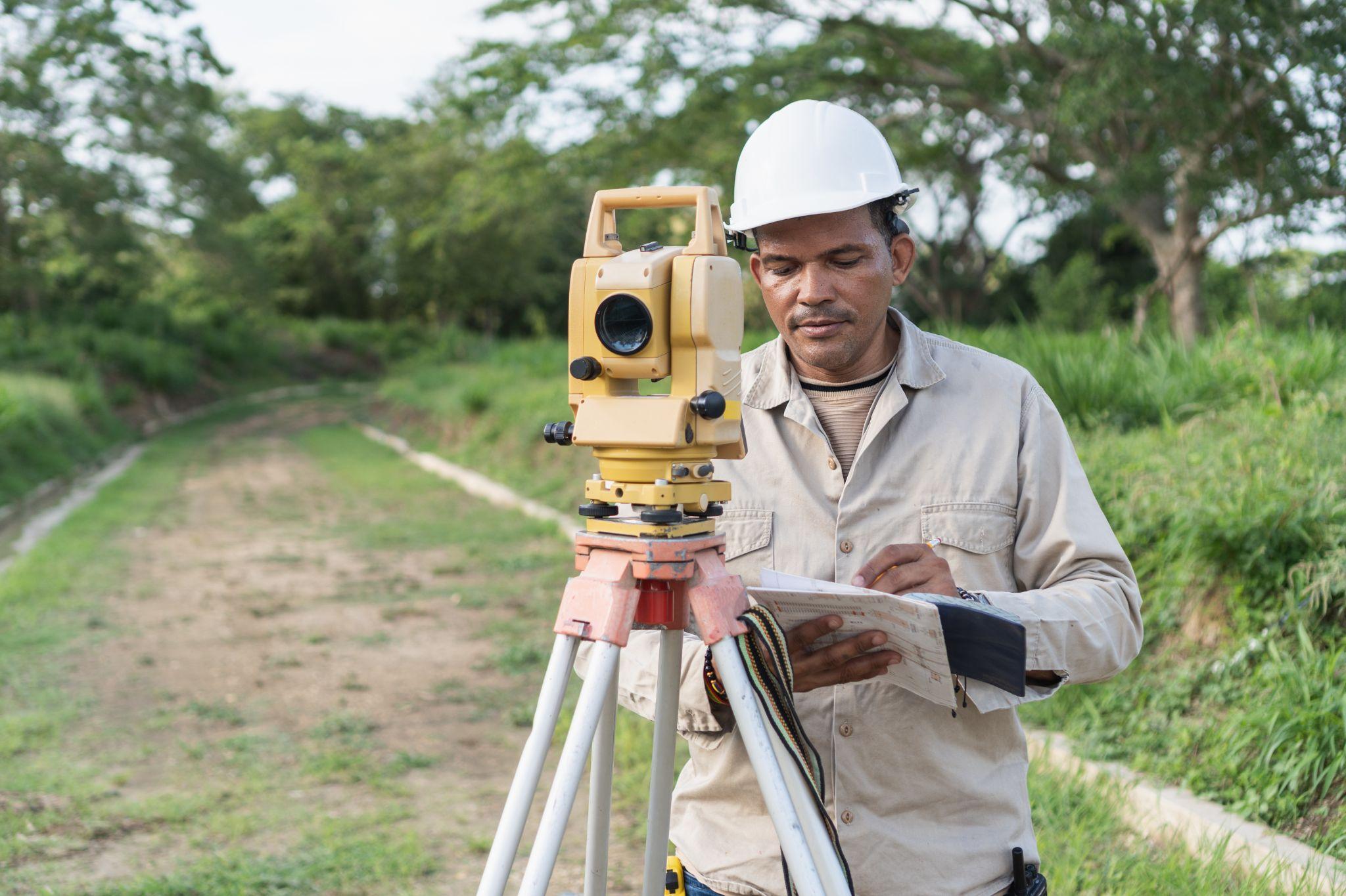 land surveyor using total station, illustrating the curiosity behind “How Long Do Land Surveying Services Take”