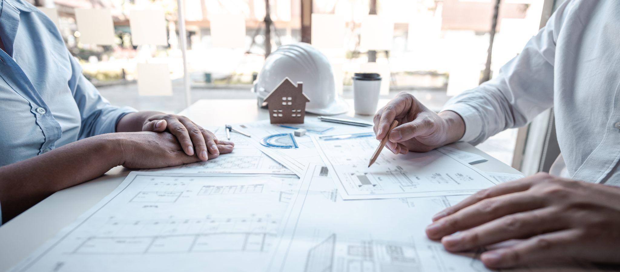 Property professionals reviewing construction plans before scheduling survey fieldwork