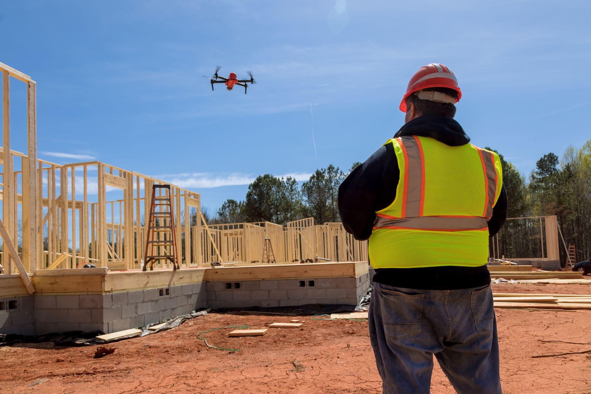 Construction supervisor overseeing a drone survey at a residential building site