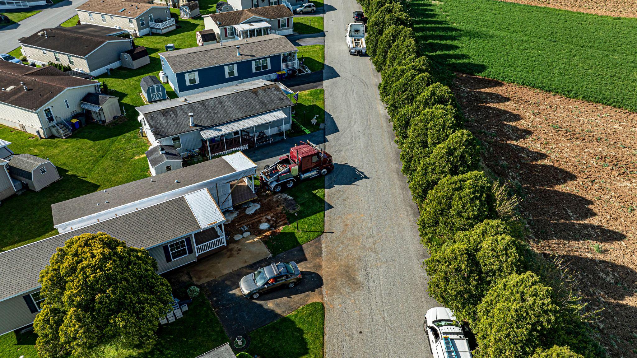 Aerial view of residential properties beside farmland and an access road