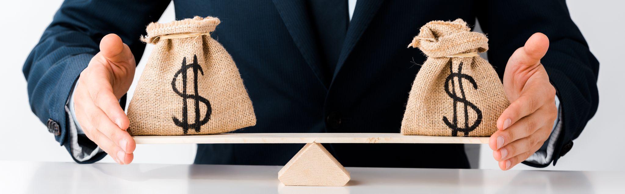 Balanced money bags representing cost comparisons when reviewing a commercial land surveying quote.