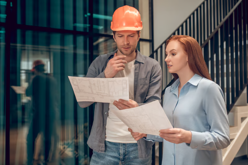 Property owner and construction professional reviewing plans and survey requirements.