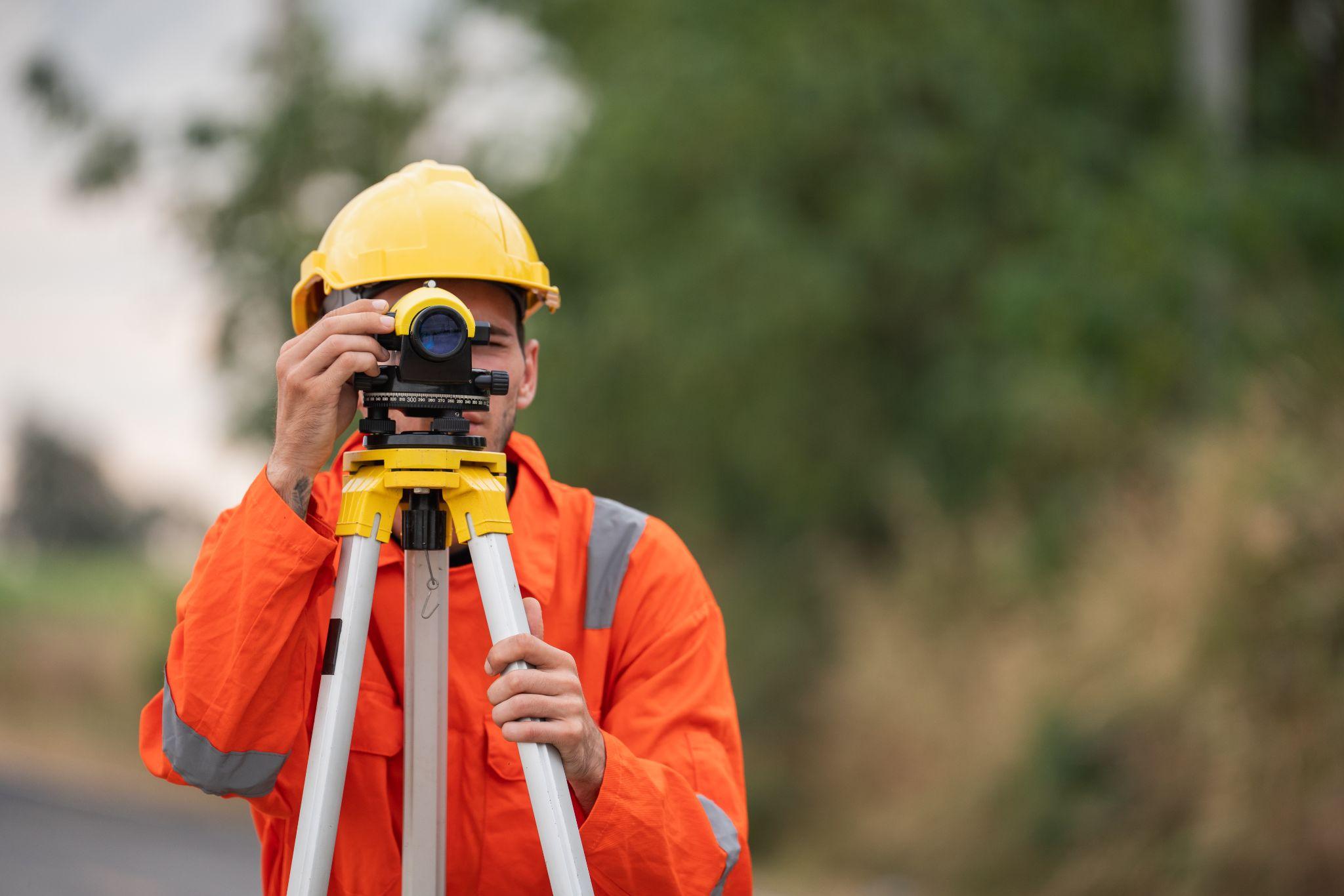 Professional land surveyor operating surveying equipment during property fieldwork