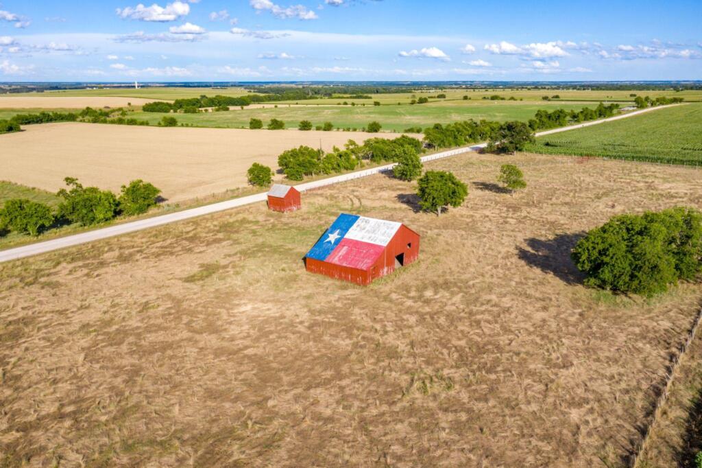 Rural Texas property with farmland and a barn displaying the Texas flag
