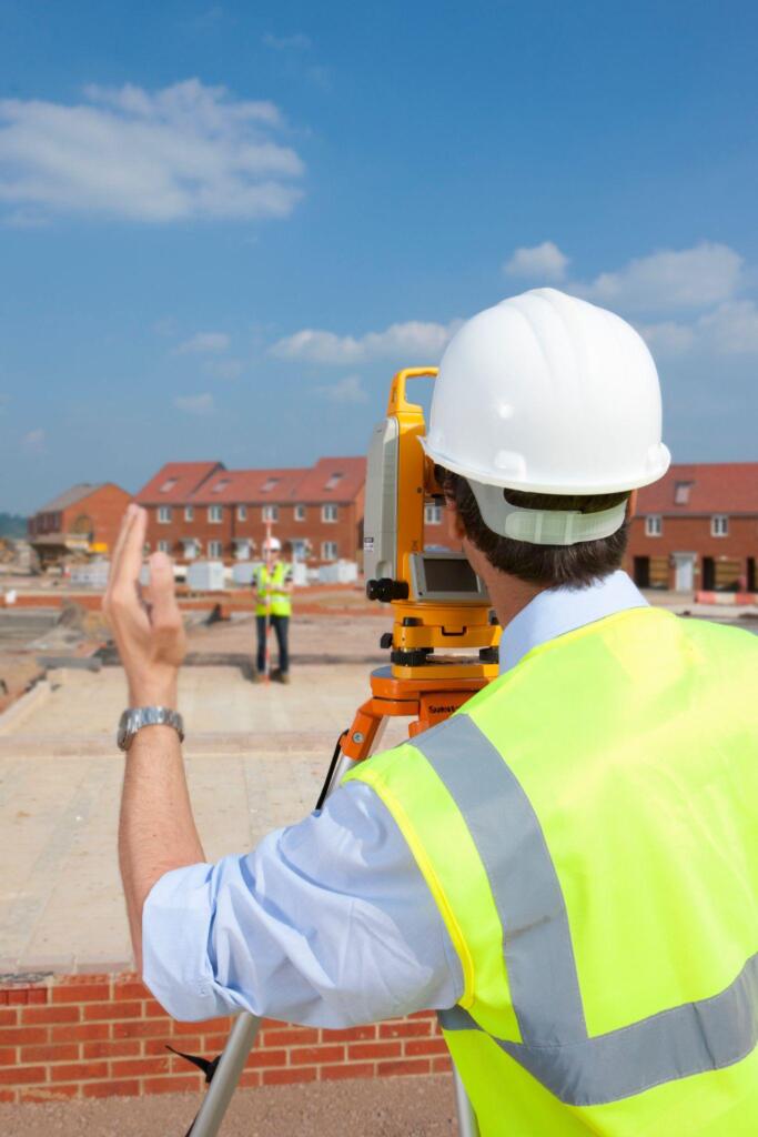 Land surveying team using surveying equipment for a development project
