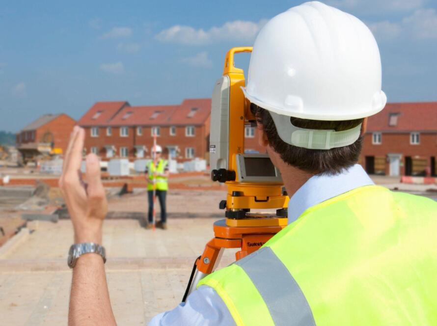 Land surveying team using surveying equipment for a development project
