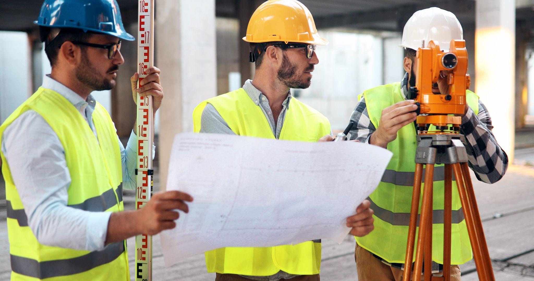 Development team reviewing plans and survey information at an active construction site