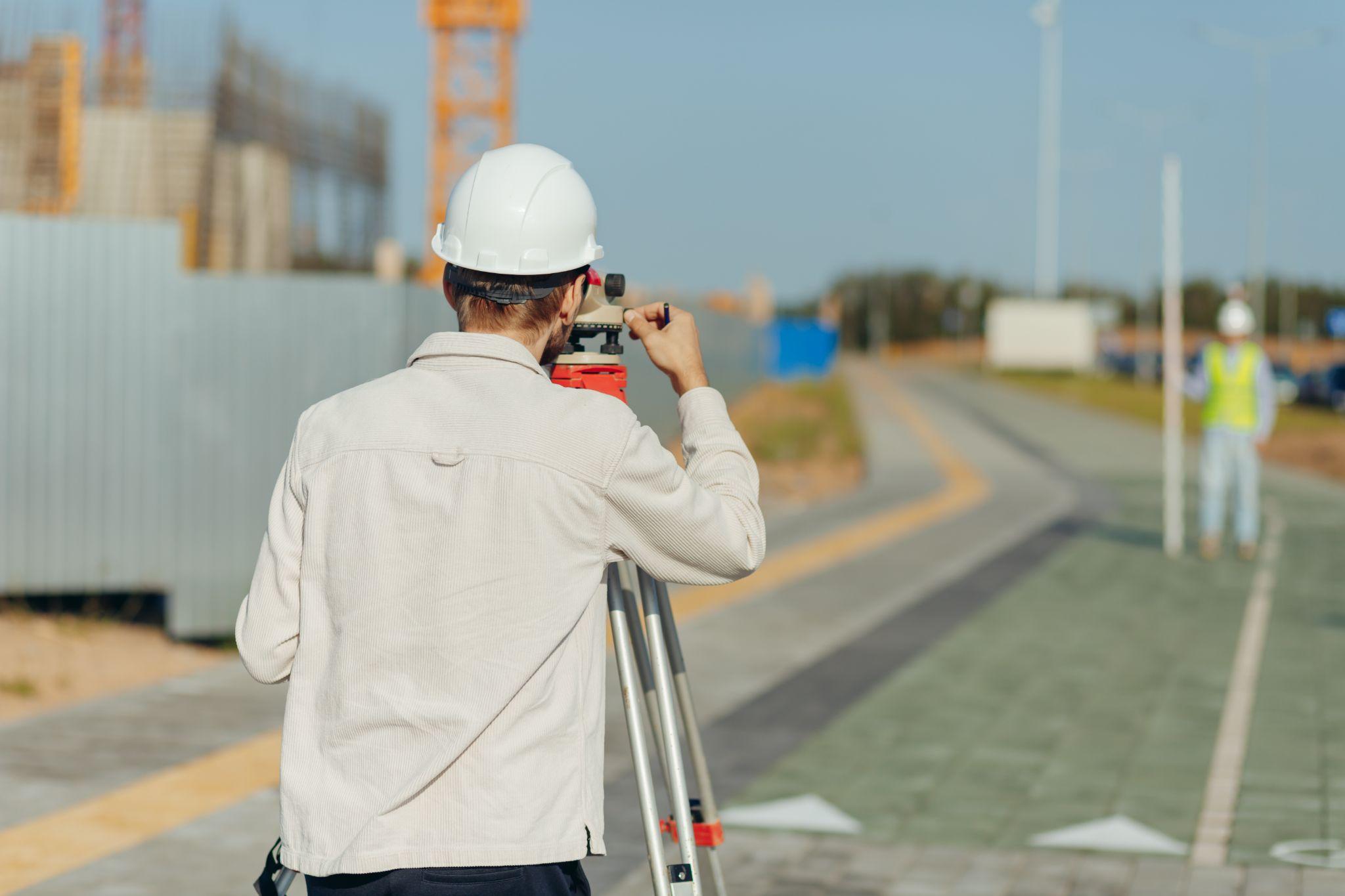 Surveyor using professional equipment during land development fieldwork