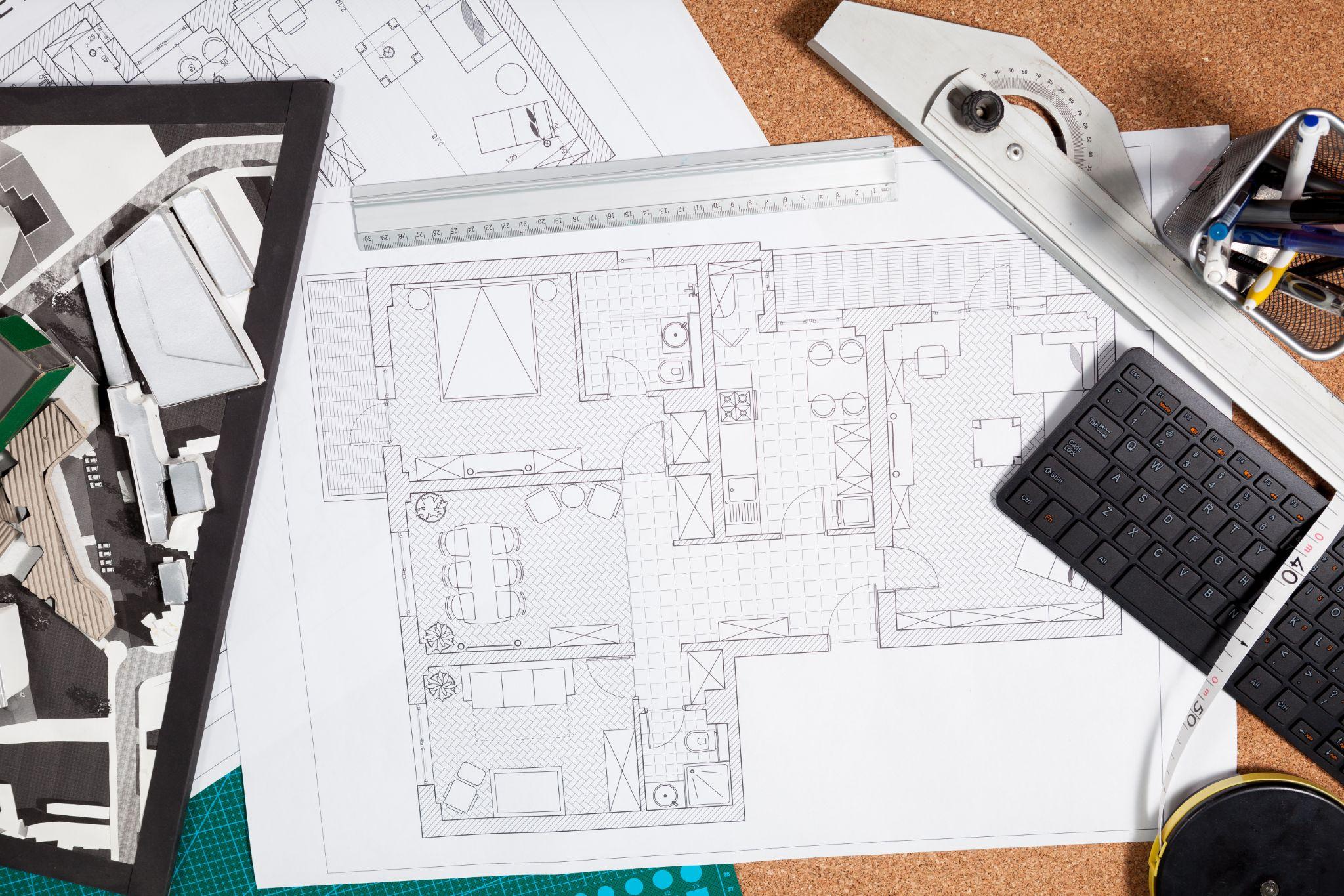 Property plans and measuring tools reviewed during a land survey consultation