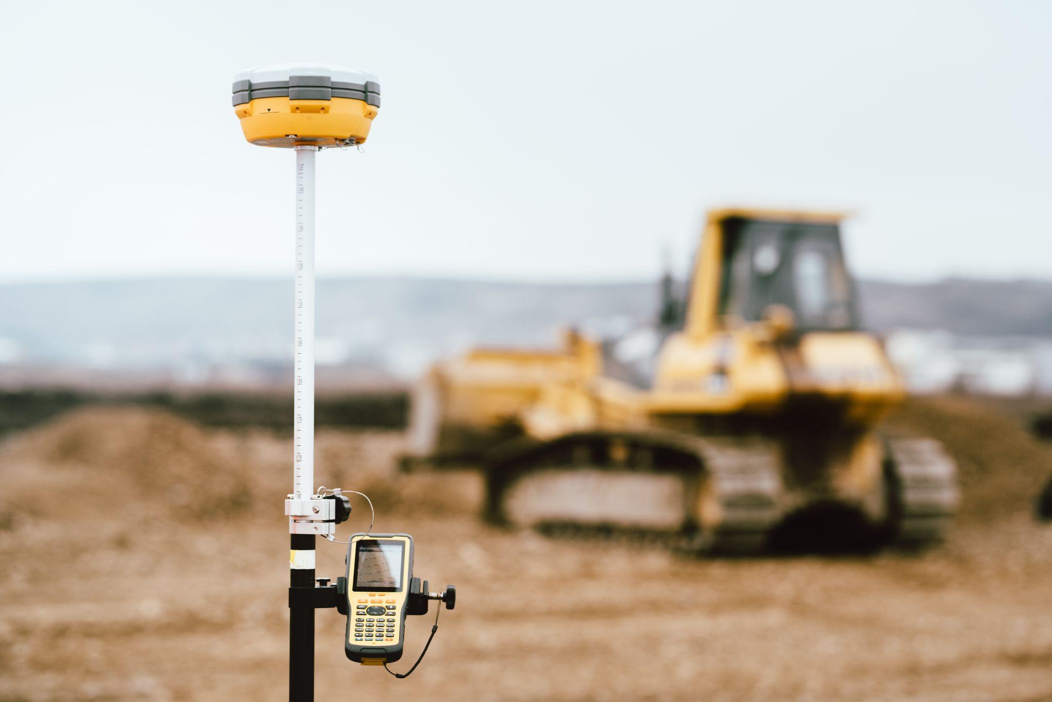 Surveying equipment positioned at an active construction site before site development