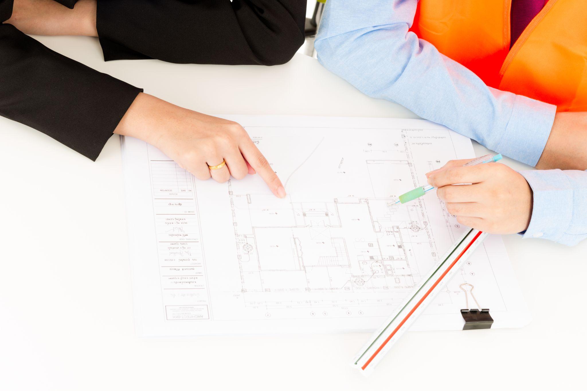 Professionals reviewing property plans and project documents together