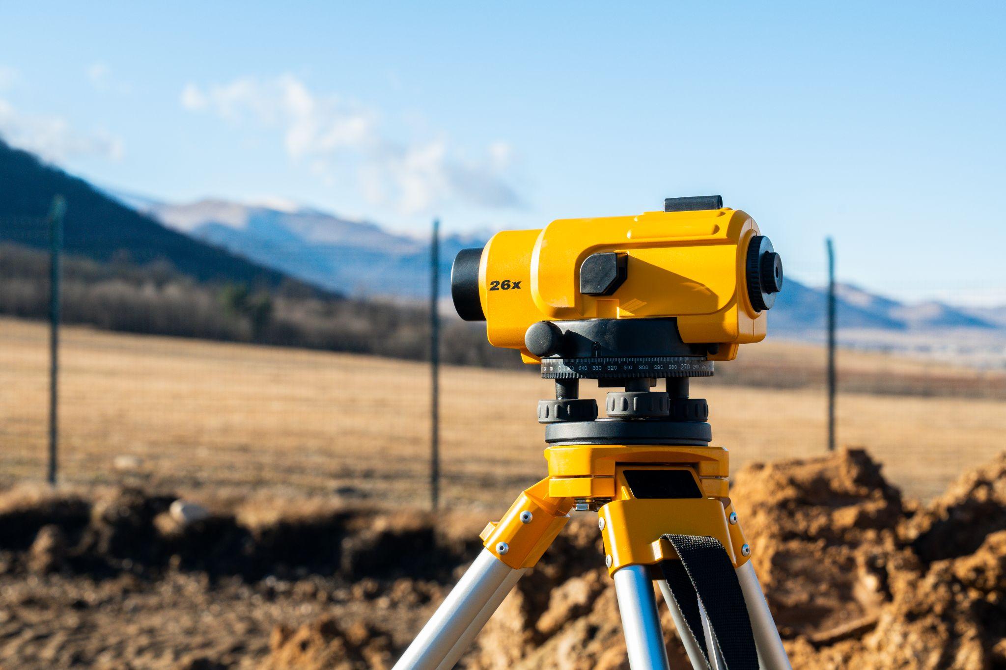 Surveying instrument positioned in a rural field for land measurement