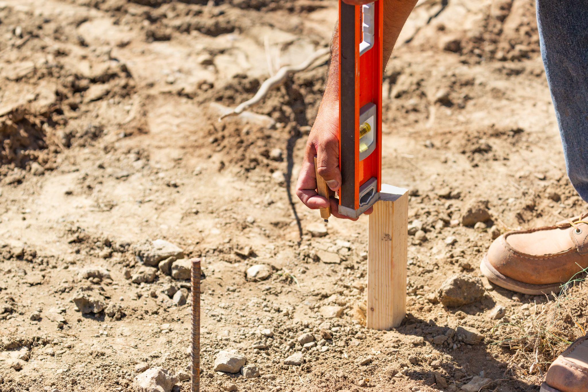 Property marker being checked during professional land surveying fieldwork