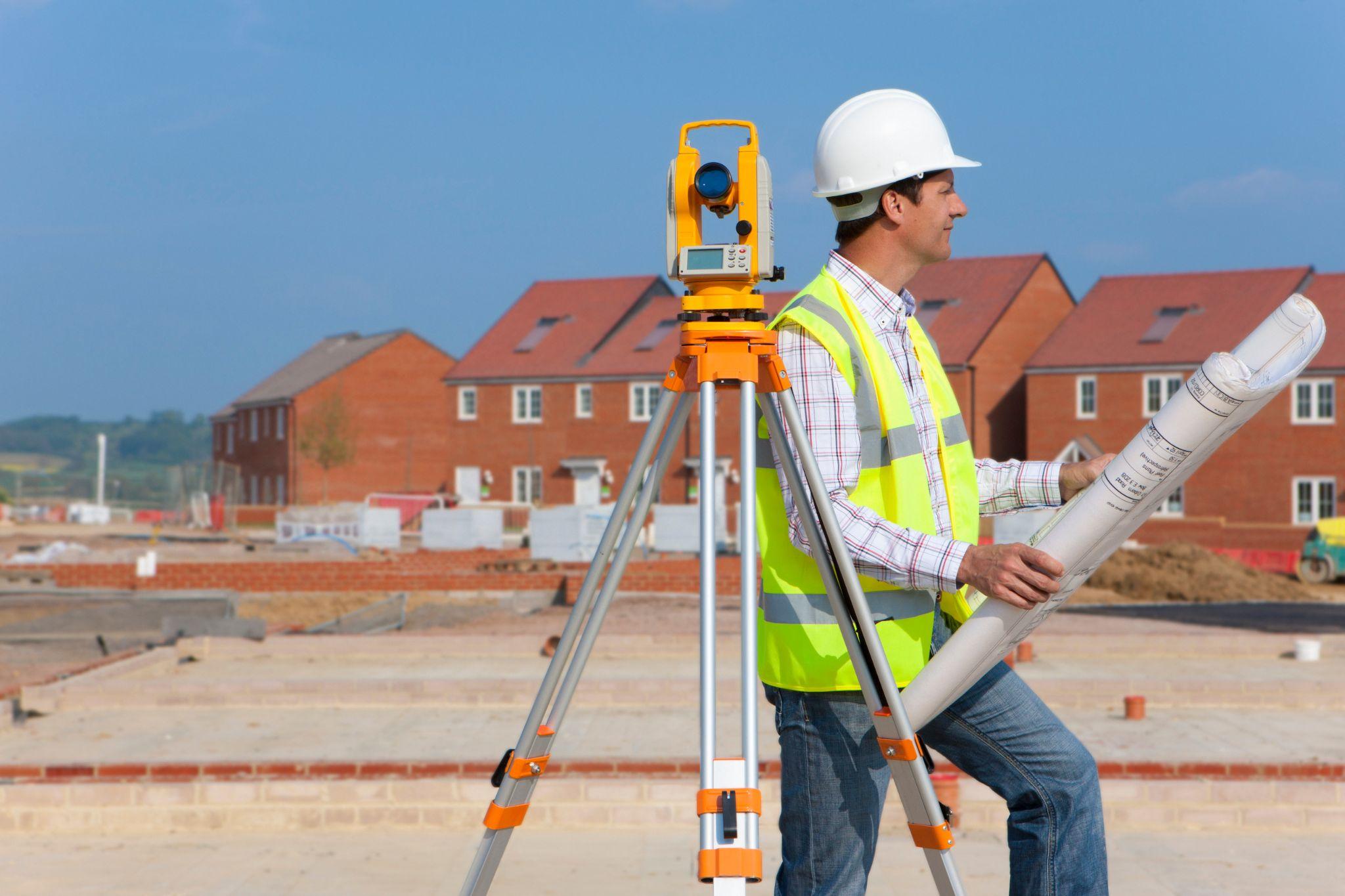 Land surveyor reviewing site plans at a residential development project