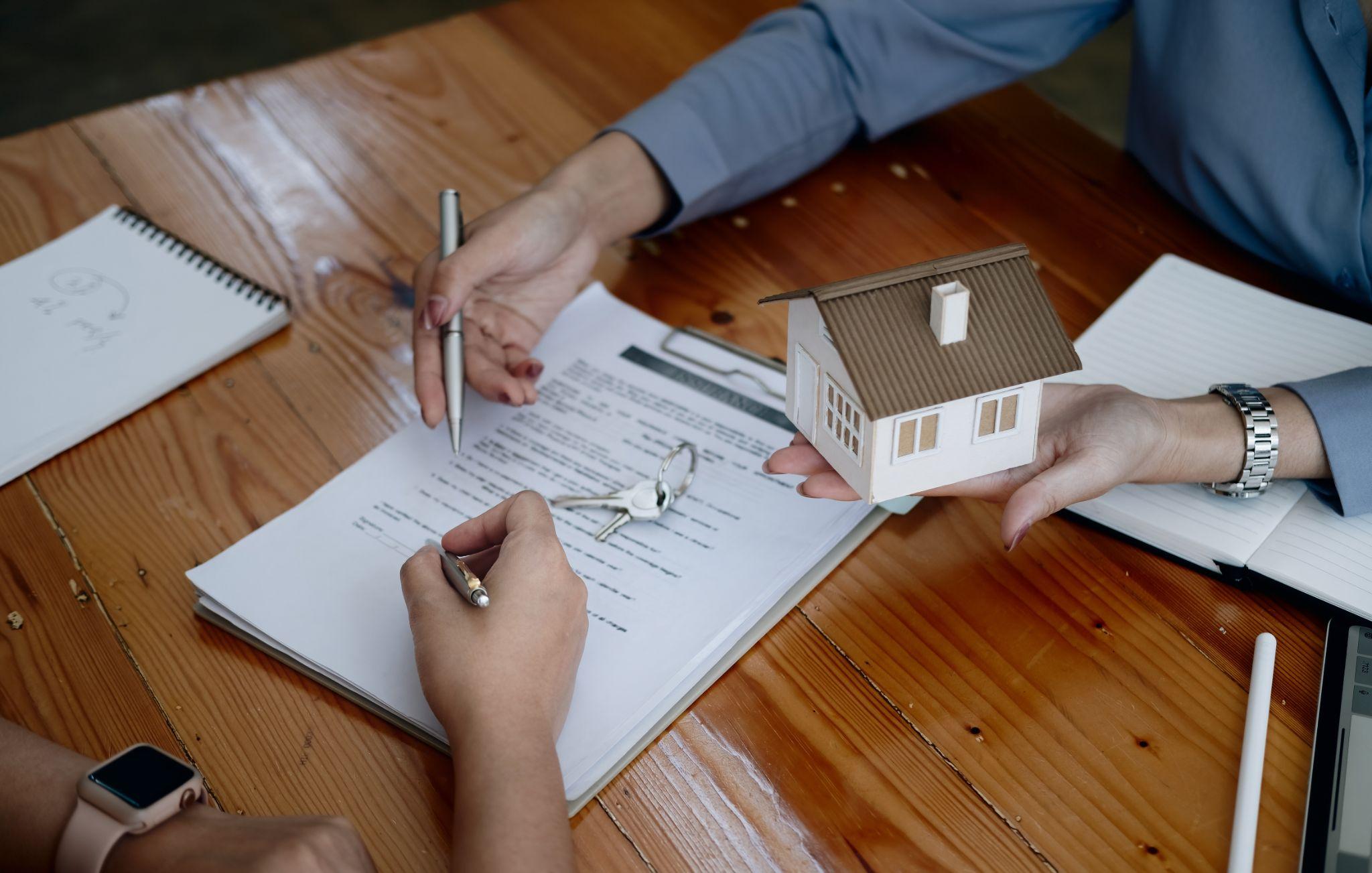 Property owner reviewing and signing real estate documents for a home transaction