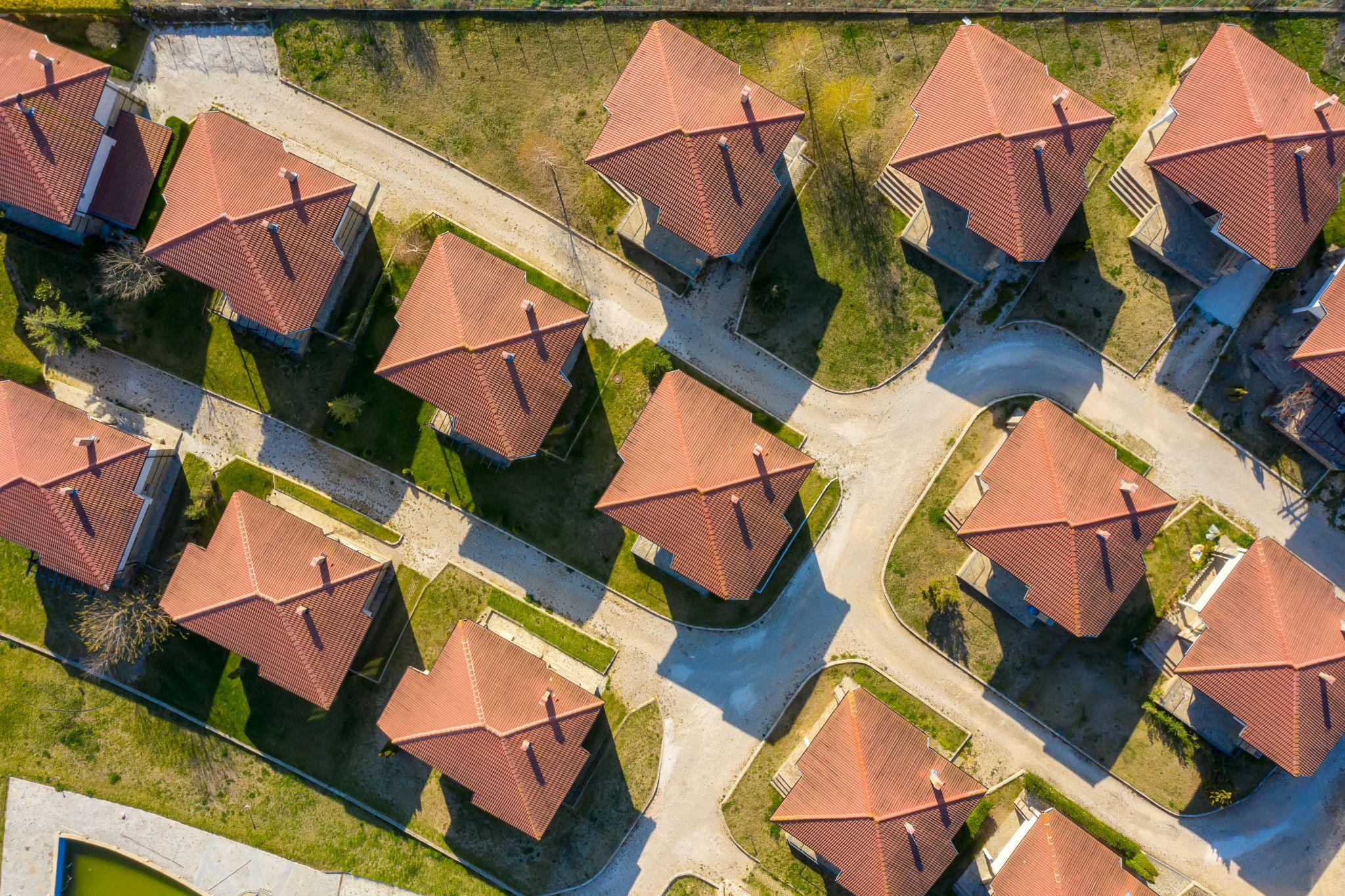 Aerial view of residential properties and surrounding land in a suburban area