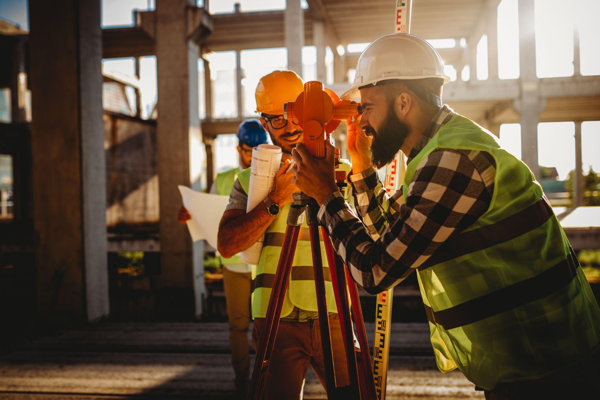 Land surveying professionals taking measurements at a construction site