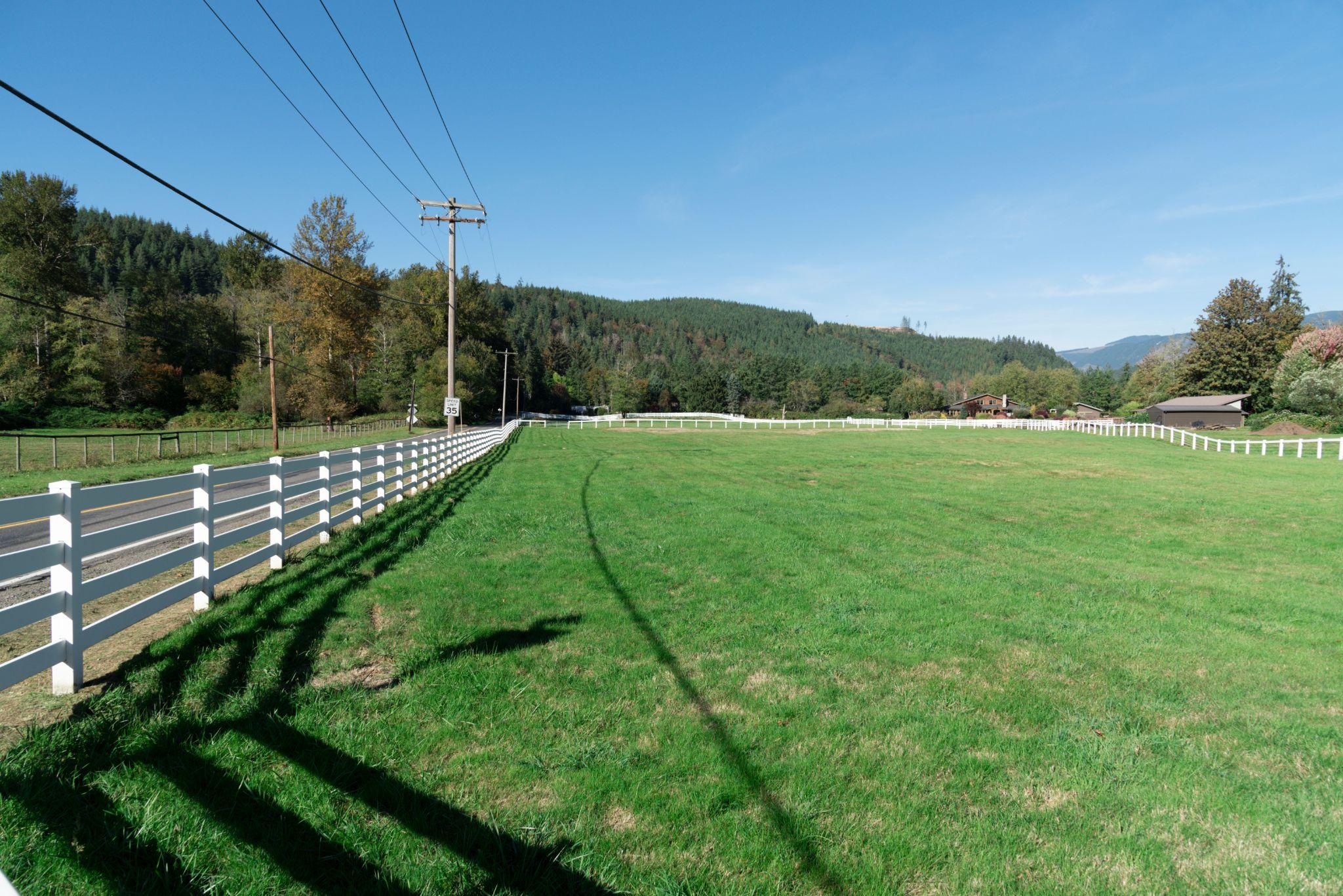 Fence running along the edge of a large grassy property