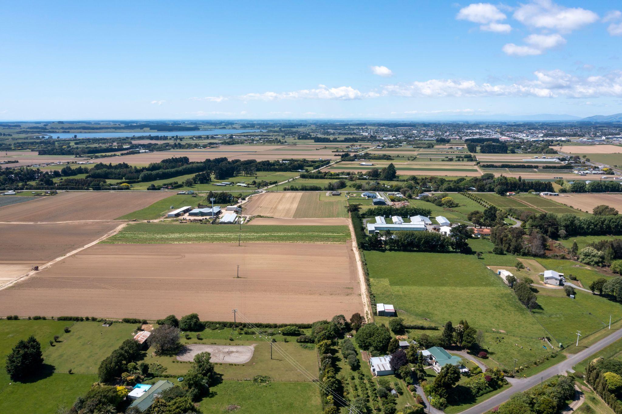 Aerial view of farmland, roads, homes, and surrounding properties